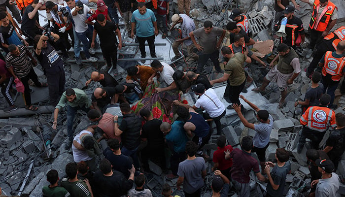 Rescuers and people remove a body from under the rubble of a collapsed building following an Israeli air strike on Rafah in southern Gaza Strip on October 26, 2026. — AFP