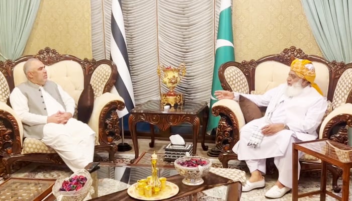 PTIs senior leader Asad Qaiser (left) during the meeting with JUI-F chief Maulana Fazlur Rehman in Islamabad, on October 26, 2023, in this still taken from a video. — X/@juipakofficial