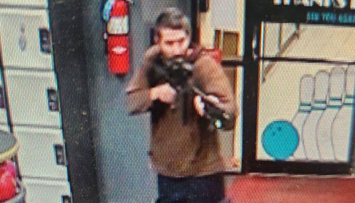 A man identified as a suspect by police points what appears to be a semiautomatic rifle, in Lewiston, Maine, US, October 25, 2023. — Reuters