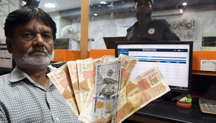 A foreign exchange dealer counts US dollars at a shop in Karachi on March 2, 2023. — Online