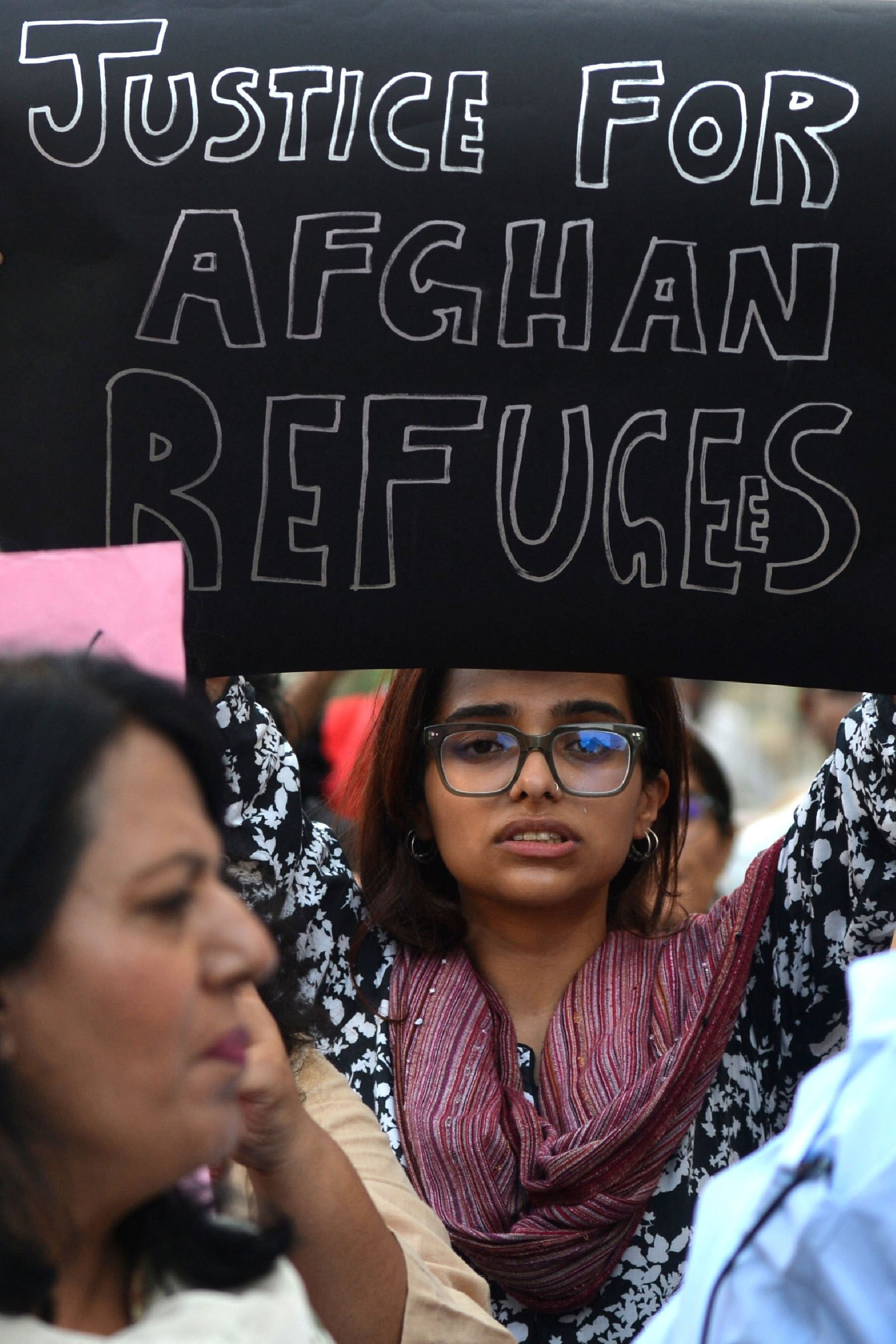 A woman holds a placard as she protests against the deportation of Afghans from Pakistan, at a rally organised by women´s movement Aurat March, in Karachi on October 29, 2023. — AFP