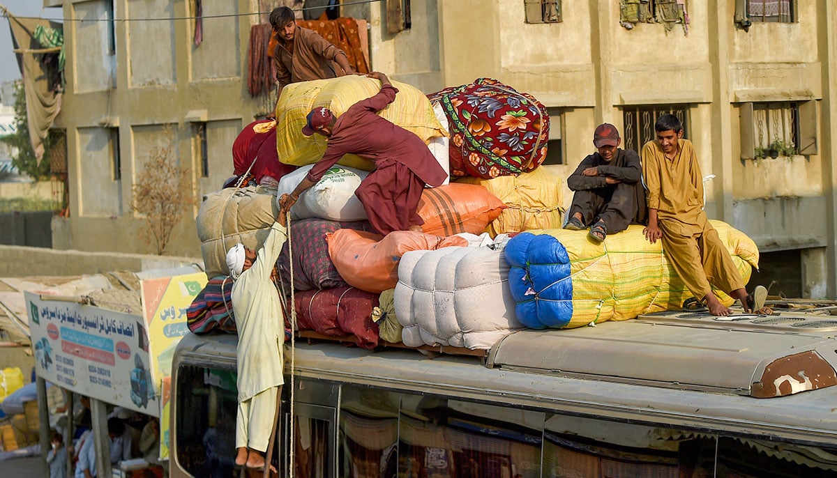 Afghan refugees depart for Afghanistan from the Karachi bus terminal in Sindh province on October 30, 2023. — AFP