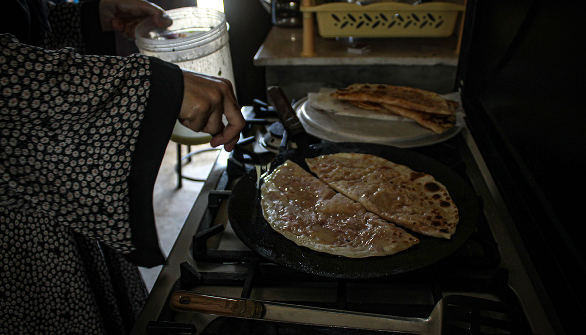 Roshan prepares Bolani on the stove. — Hassaan Ahmed