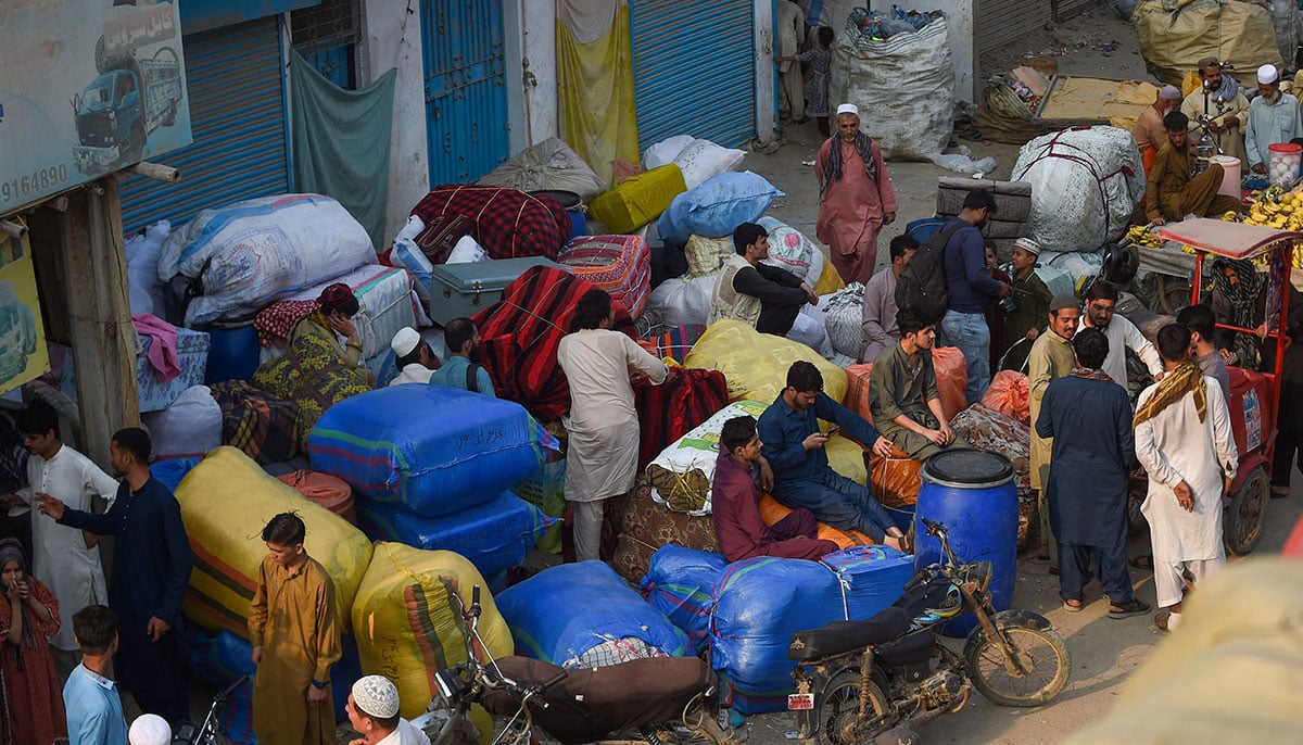 Afghan refugees wait at the Karachi bus terminal in Sindh province, to depart for Afghanistan on October 30, 2023. — AFP