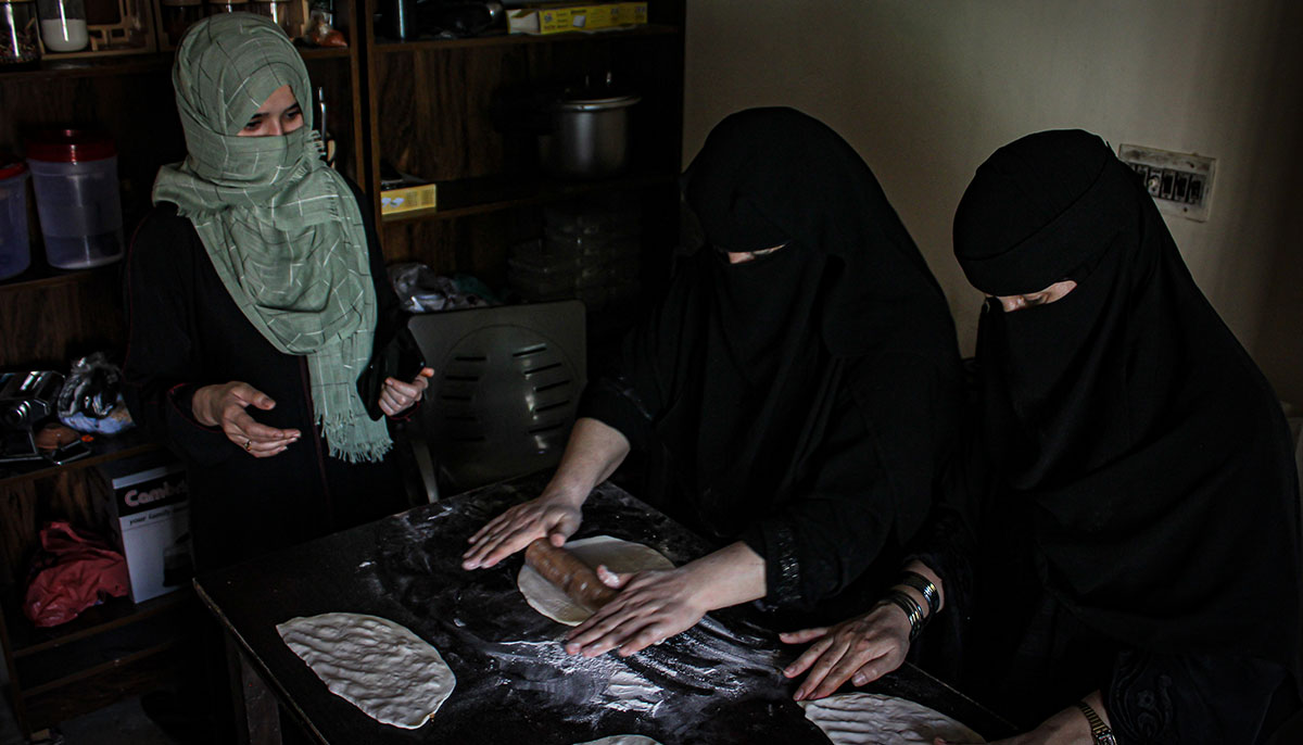 Wajiha Jumma Khan stands alongside her colleagues in the cafes kitchen. — Hassaan Ahmed
