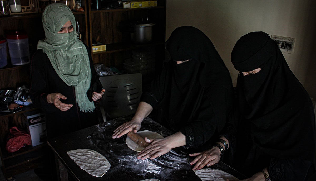 Wajiha Jumma Khan stands alongside her colleagues in the cafes kitchen. — Hassaan Ahmed