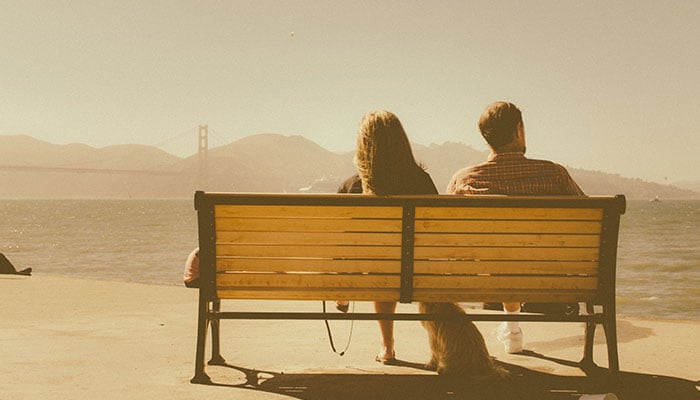 A representational image of a couple sitting on a bench. — Unspalsh