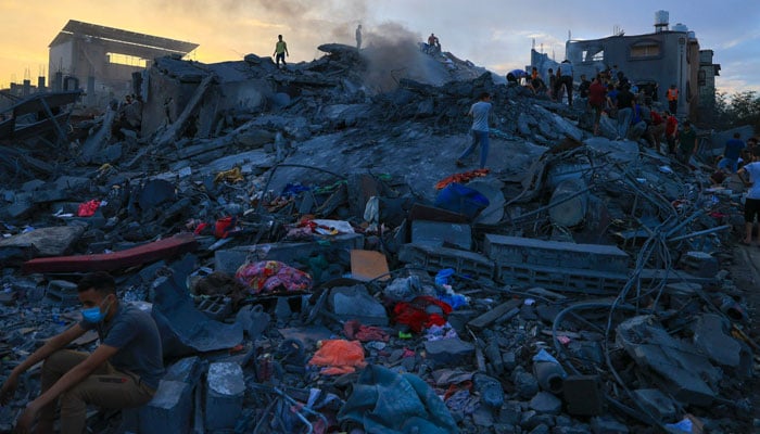 Palestinians search for survivors in the rubble of a building in the Nuseirat refugee camp, in the central Gaza Strip on October 31, 2023, amid relentless Israeli bombardment of the Palestinian enclave. — AFP