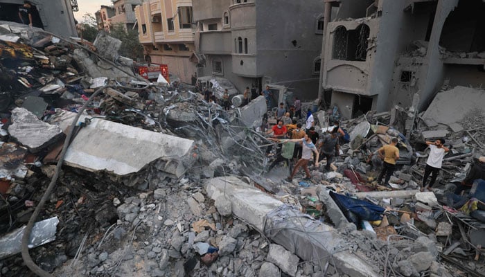 Palestinians search for survivors in the rubble of a building in the Nuseirat refugee camp, in the central Gaza Strip on October 31, 2023, amid relentless Israeli bombardment of the Palestinian enclave. — AFP