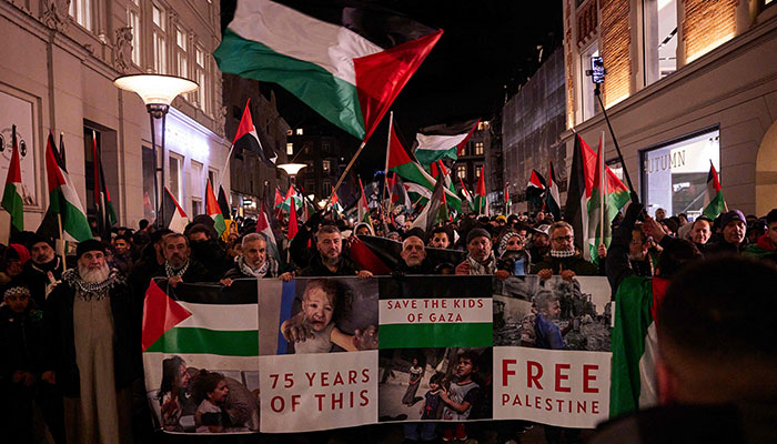 People walk past in a pro-Palestinian demonstration in Aarhus, Denmark, on October 31, 2023. — AFP