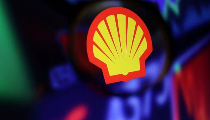 The Shell logo and stock chart are seen through a magnifying glass shown in this image taken on September 4, 2022. — Reuters
