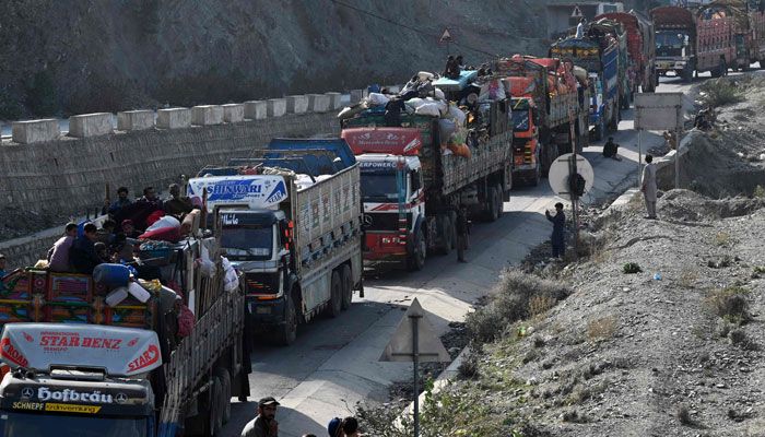 Trucks transporting Afghan refugees with their belongings are seen along a road towards the Pakistan-Afghanistan Torkham border on November 3, 2023. — AFP