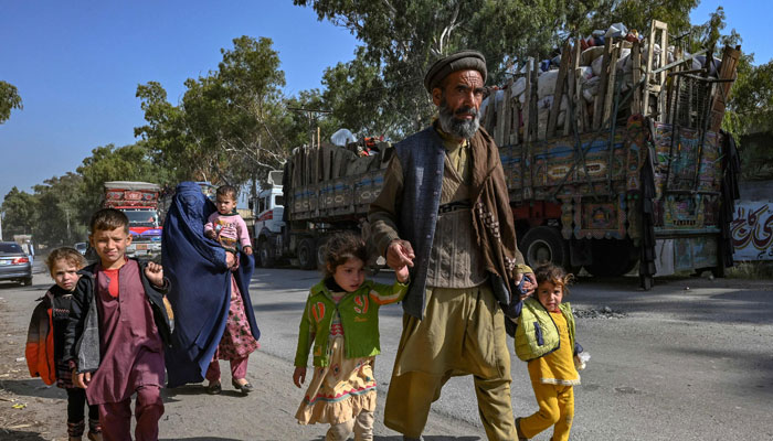 An Afghan refugee family living in Pakistan arrives outside the United Nations High Commissioner for Refugees (UNHCR) repatriation center, some 25 Km from Peshawar on October 25, 2023. — AFP