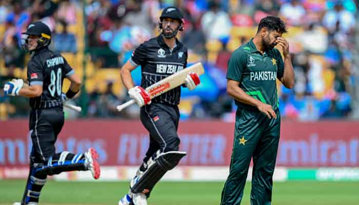 Haris Rauf (R) gestures as New Zealands Daryl Mitchell and Mark Chapman (L) run between the wickets during the 2023 ICC Men´s Cricket World Cup one-day international (ODI) match between New Zealand and Pakistan at the M. Chinnaswamy Stadium in Bengaluru on November 4, 2023. —AFP