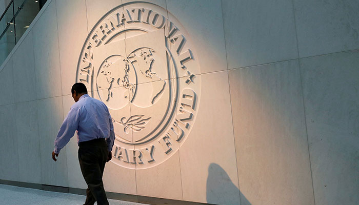 A man walks past the International Monetary Fund (IMF) logo at its headquarters in Washington, U.S., May 10, 2018. — Reuters