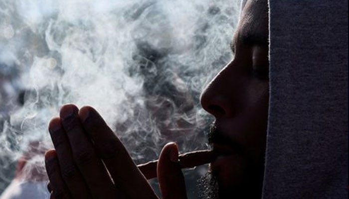 A man smokes marijuana in Washington Square Park as marijuana enthusiasts mark the annual but informal celebration of cannabis.—Reuters