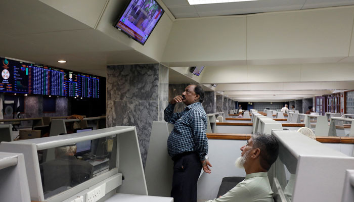 Stock brokers monitor new on television screen at a booth, during a trading session at the Pakistan Stock Exchange, in Karachi, Pakistan July 3, 2023. — Reuters