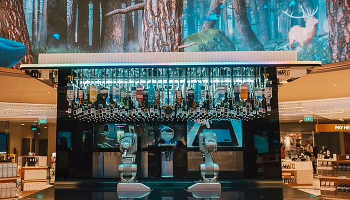 Passengers can grab a free cocktail from the terminals in-airport robot bartender Toni at the new double-storey Lotte Duty Free Wines & Spirits store.—Changi Aiprort