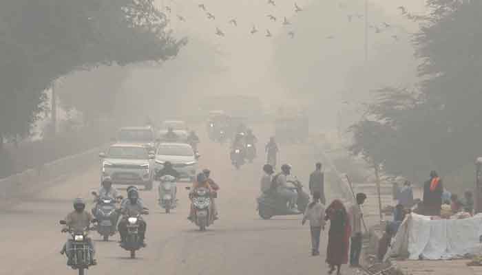 People and vehicles are seen on a road amidst the morning smog in New Delhi, India, November 8, 2023.  —Reuters