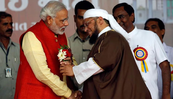Hindu nationalist Narendra Modi (2nd L), prime ministerial candidate for Indias main opposition Bharatiya Janata Party (BJP), receives flowers from a Muslim cleric after the inauguration of a hospital owned by a Muslim trust at Balasinore town, east of the western Indian city of Ahmedabad November 10, 2013. — Reuters