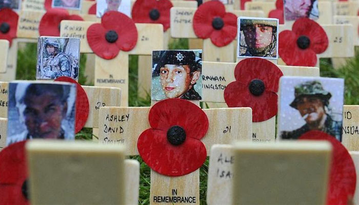 Photographs of soldiers killed on duty in Afghanistan are seen attached to replica crosses at a Field of Remembrance outside Westminster Abbey, November 11, 2010. —Reuters