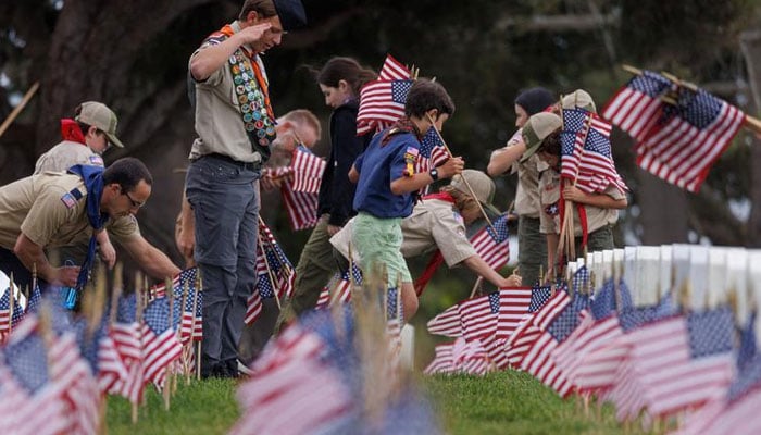 Trent Torres, of Troop 959 of Boy Scouts of America, salutes after placing an American flag on a gravesite at Fort Rosecrans National Cemetery in preparation for Memorial Day in Point Loma, San Diego, California, May 27, 2023.—Reuters