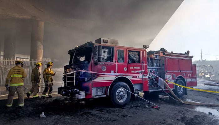Fire Engine 17, sitting under the 10 Freeway overpass on East 14th Street, was scorched in the massive pallet fire. —Los Angeles Times