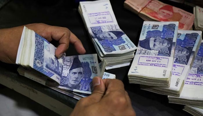 An employee counts Pakistani rupee notes at a bank in Peshawar, Pakistan August 22, 2023. — Reuters