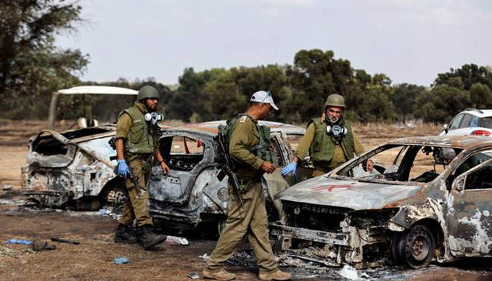 Israeli soldiers inspect the burnt cars of festival-goers at the site of an attack on the Nova Festival by Hamas gunmen. —Reuters