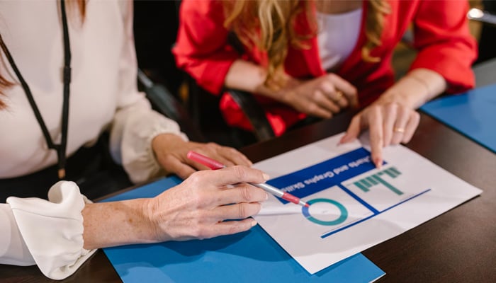 A representational image of women analysing graphs and data. — Pexels