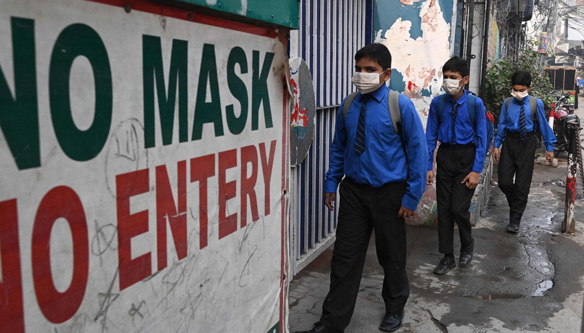 Students wearing facemasks arrive at a school in Lahore on November 2, 2023, following Punjab´s government announcement to use facemasks due to severe smoggy conditions. — AFP