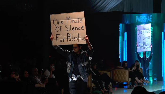 A model walks the ramp with a placard expressing solidarity with the Palestinians. — Reporter