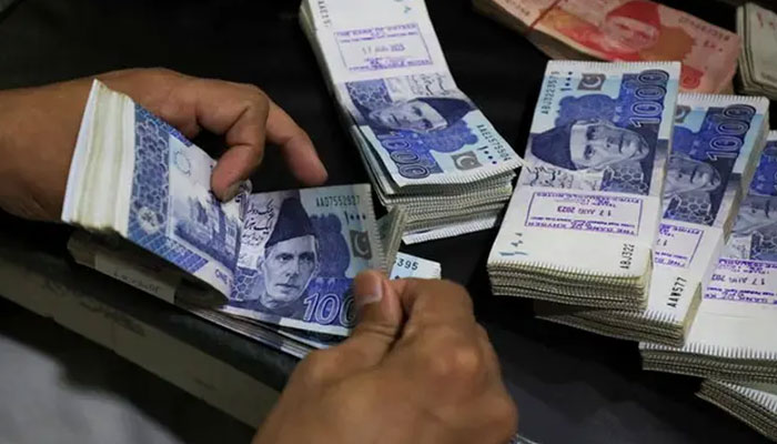 An employee counts Pakistani rupee notes at a bank in Peshawar, Pakistan, August 22, 2023. — Reuters