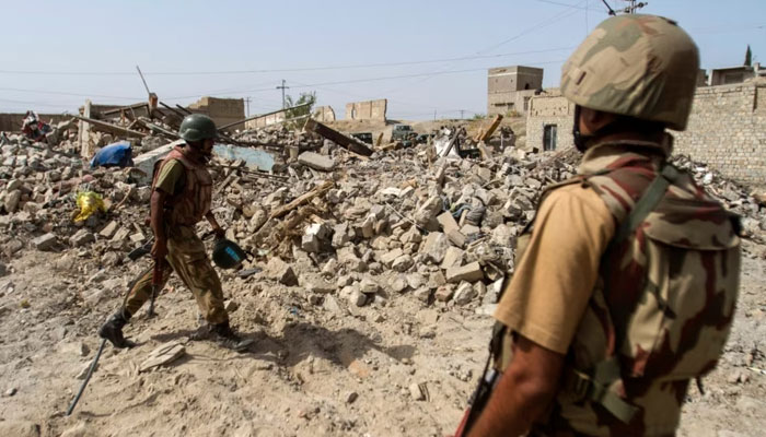 Pakistani soldiers stand near debris of a house which was destroyed during a military operation against Islamist militants in the town of Miranshah, North Waziristan, Pakistan, July 9, 2014. — Reuters
