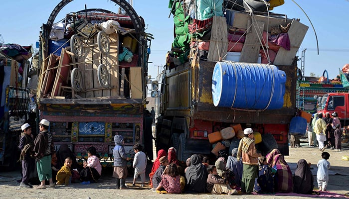 Afghan refugees sit beside their belongings at a registration centre upon their arrival from Pakistan, near the Afghanistan-Pakistan border in the Spin Boldak district of Kandahar province on November 20. — AFP