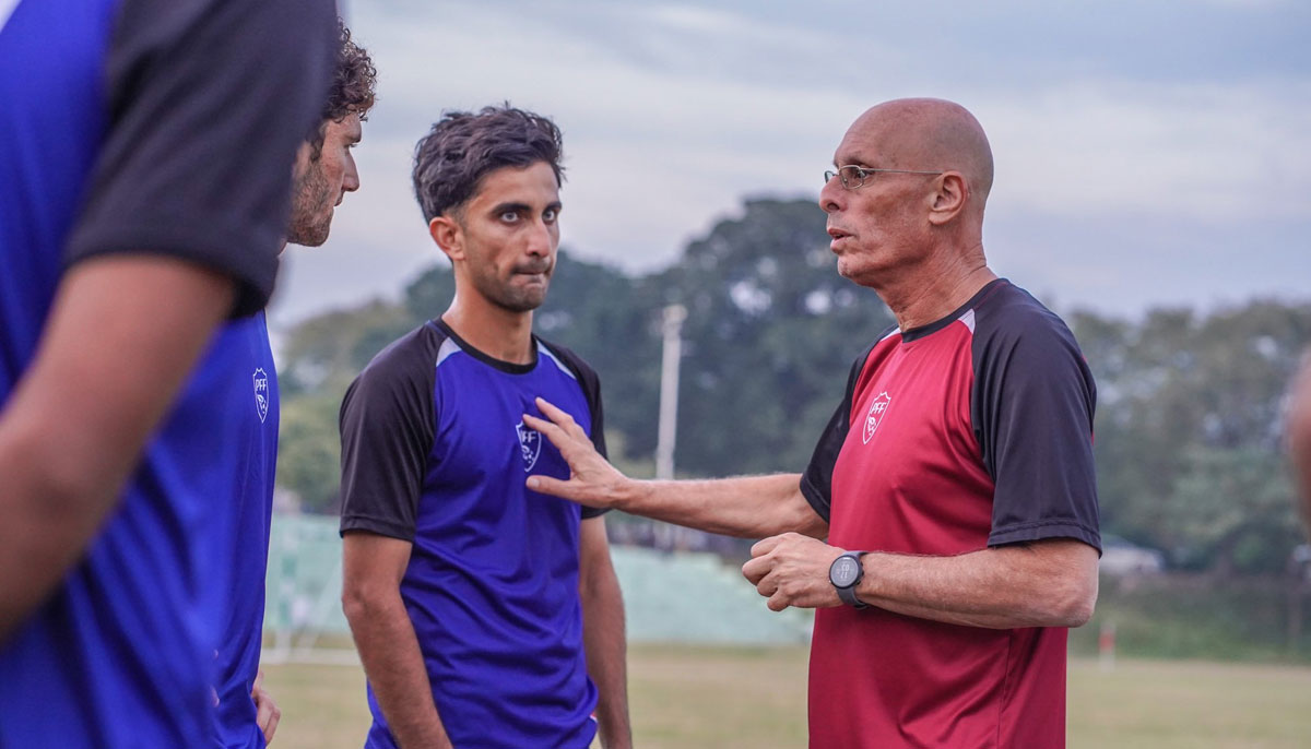 Head Coach Stephen Constantine speaks with Pakistani footballers ahead of a match. — X/@TheRealPFF