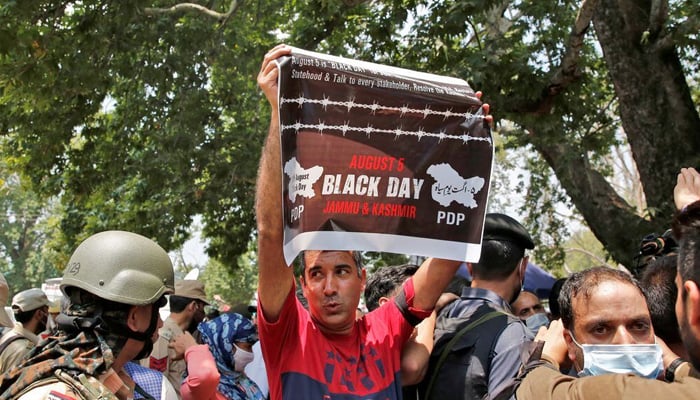 A supporter of the Peoples Democratic Party (PDP), a pro-India political party, holds up a poster during a protest demanding the restoration of IIOJK autonomy, in Srinagar August 5, 2021. — Reuters