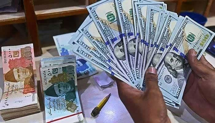 A foreign exchange dealer counts US dollars in a shop in Karachi.  — AFP/File