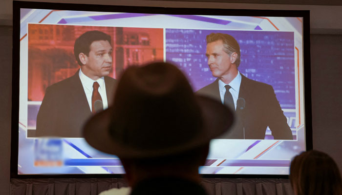 Journalists watch Florida Governor and Republican presidential candidate Ron DeSantis debate California Governor Gavin Newsom on a screen in the media room, in Alpharetta, Georgia, US, November 30, 2023. — Reuters