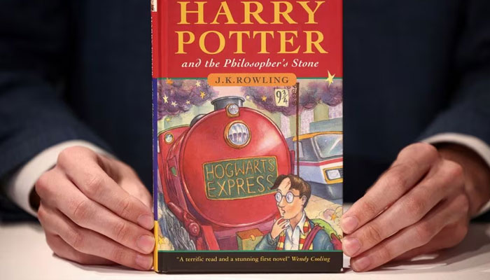 A person holds a rare first edition and signed by the author copy of Harry Potter and the Philosophers Stone by British author J.K. Rowling, which is to be put up for sale at Christies auction house in London, Britain May 31, 2022.—Reuters