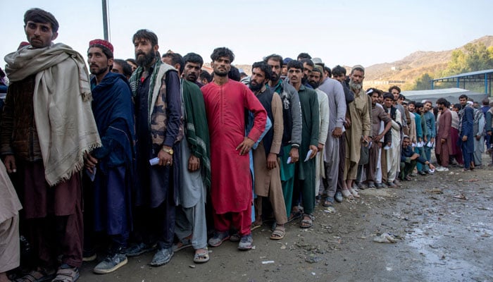 Afghan nationals stand in a queue as they wait to undergo screening to access humanitarian aid at the Torkham border crossing between Pakistan and Afghanistan, October 30, 2023. — Reuters