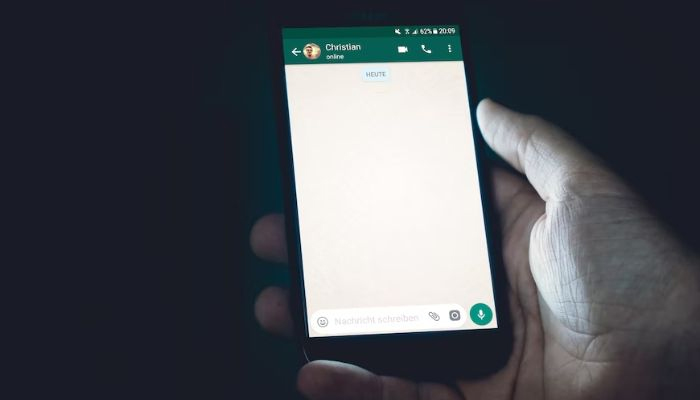 Images shows a person holding a phone with WhatsApp.— Unsplash