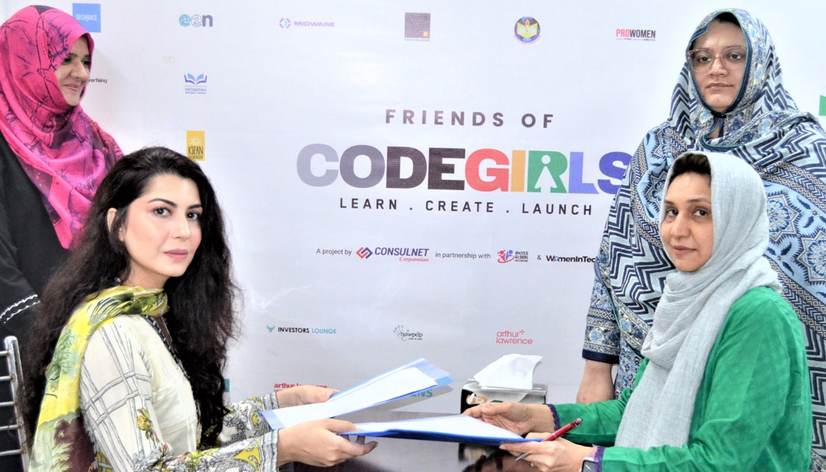 Faiza Yousuf (extreme right) and Samana Hassan (extreme left) with the CodeGirls team, signing an MoU with TechValley. — Photo by author