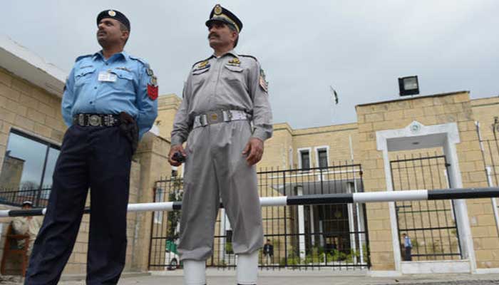 Policemen stand in front of the Election Commission of Pakistan (ECP) office in Islamabad. — AFP