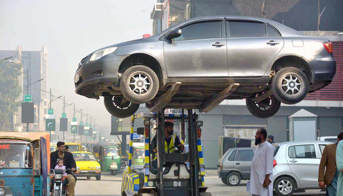 Representational image of a traffic police warden removing wrongly parked vehicles with the help of a forklift for smooth traffic flow. — APP/File