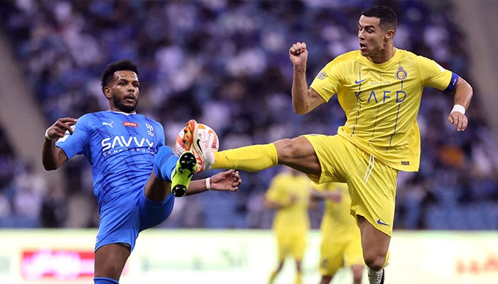 Cristiano Ronaldo in action with Ali Al Bulayhi during the Al Hilal vs Al Nassr match at King Fahd International Stadium in Riyadh, Saudi Arabia on December 1, 2023. — Reuters