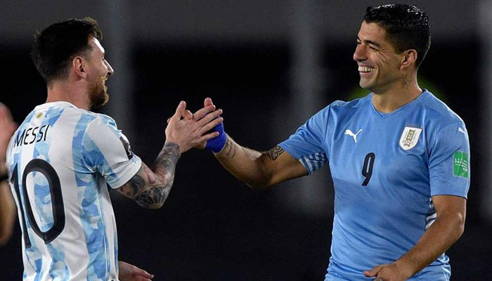 Argentinas Lionel Messi greets Uruguayan player Luis Suarez in this undated picture. — AFP/File