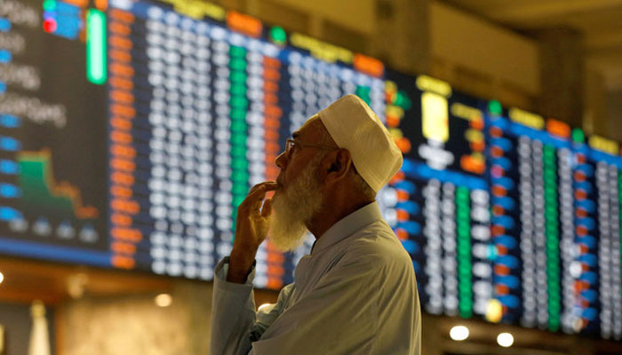 A stock broker reacts while monitoring the market on the electronic board displaying share prices during trading session at the Pakistan Stock Exchange, in Karachi, Pakistan July 3, 2023. — Reuters