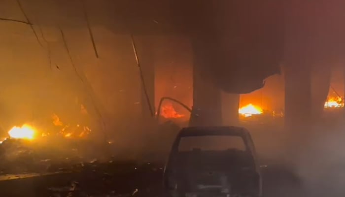 A completely destroyed car outside the building that caught fire near Karachi’s Ayesha Manzil, on December 6, 2023, in this still taken from a video. — Geo.tv via Syed Daniyal Syed