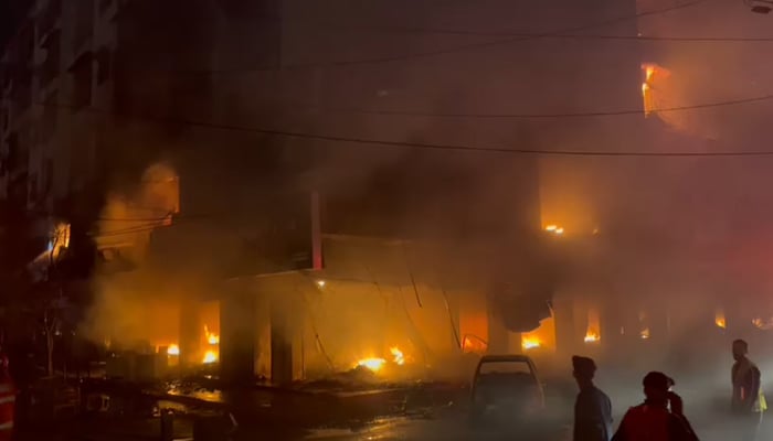 Flames can be seen coming out of the building that caught fire near Karachi’s Ayesha Manzil, on December 6, 2023, in this still taken from a video. — Geo.tv via Syed Daniyal Syed
